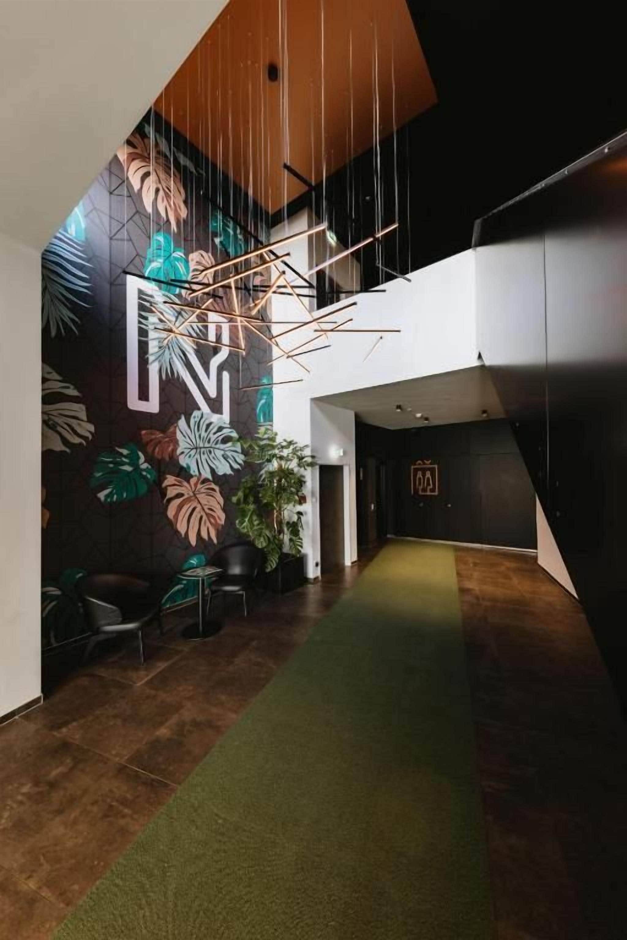 Een modern interieur met een geometrisch wandontwerp, een groen tapijt en een receptiebalie.