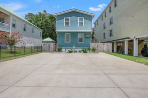 A two-story residential building with a blue exterior and a front yard.