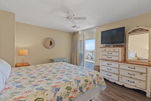 A hotel room with a bed, a television, a dresser, and a balcony with a view. - Hyperion 401 Oceanfront 3BR 2BA with Outdoor Pool (North Myrtle Beach)