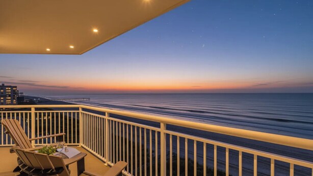 A balcony with a view of the ocean at dusk. - Hyperion 604 Oceanfront Sleeps 8-Outdoor Pool (North Myrtle Beach)