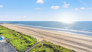 A beach with a wooden walkway leading to a parking area. - Hyperion 604 Oceanfront Sleeps 8-Outdoor Pool (North Myrtle Beach)