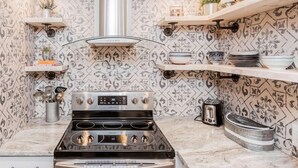 A kitchen with a stainless steel stove, a toaster, and decorative tiles. - OSU 6D · Newly Renovated (6D) OSU/Central ❤Near EVERYTHING (Columbus)