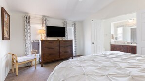A bedroom with a bed, a dresser, a television, and a bench. - The Villa - Amazingly Comfortable King Beds (Alpine)