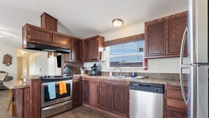 A modern kitchen with wooden cabinets, stainless steel appliances, and a built-in island. - The Villa - Amazingly Comfortable King Beds (Alpine)