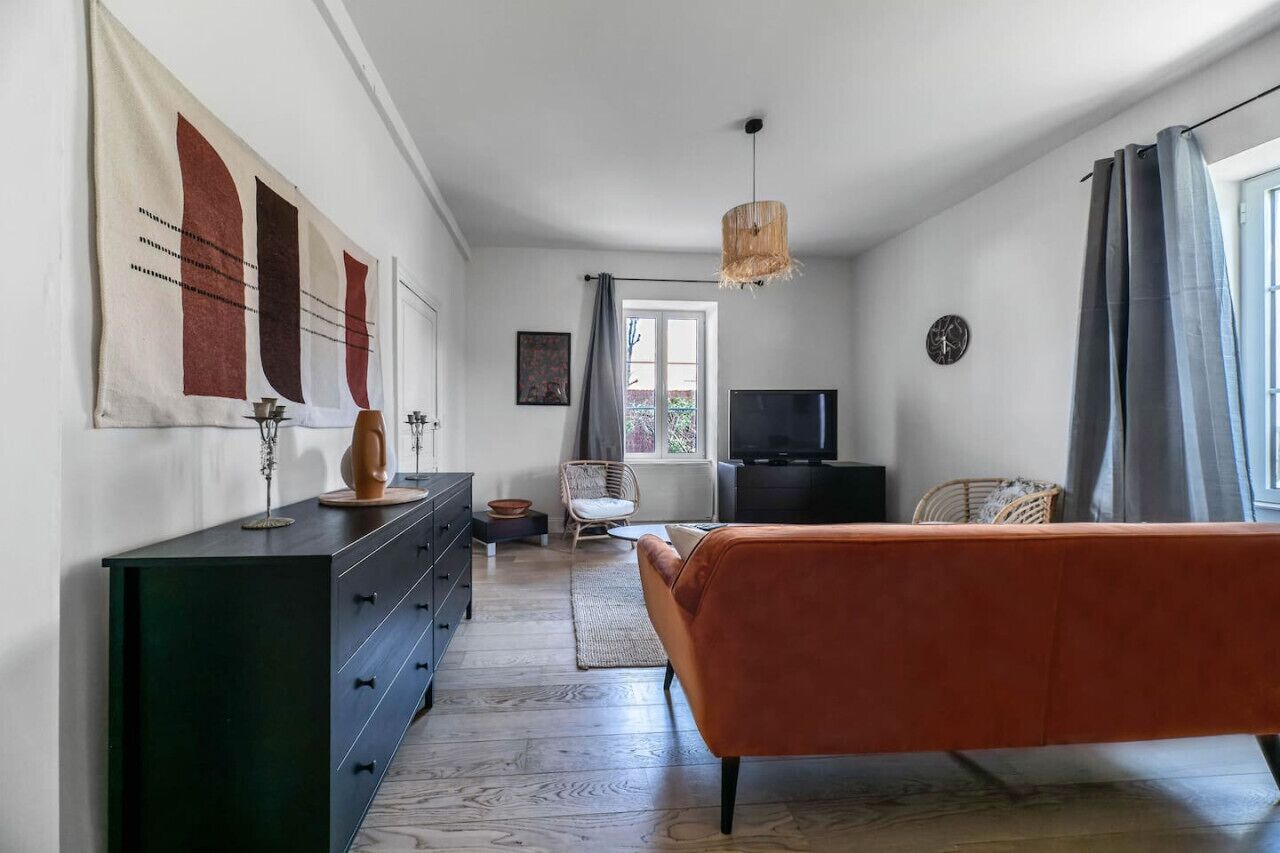 Ein modernes Schlafzimmer mit Bett, Schminktisch, Fernseher und Bildern an der Wand.