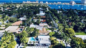 A coastal residential area with houses, palm trees, and a marina with boats. - Tropical Paradise, walking distance to the beach and heated pool! (Hollywood)