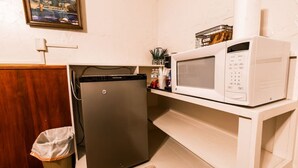 A compact kitchenette with a refrigerator, microwave, and a trash bin. - Sleeps 6  - Historic Hotel in Centennial (Centennial)