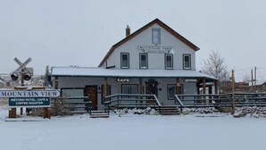 Un hotel histórico con cafetería y tostadora de café, situado cerca de un paso de tren.