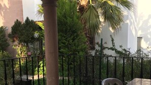 A balcony with a table and chairs, surrounded by a black metal railing. - Beachside House in Gundogan (Bodrum)