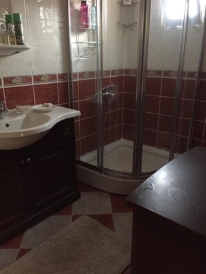 A bathroom with a shower, sink, and tiled walls. - Beachside House in Gundogan (Bodrum)