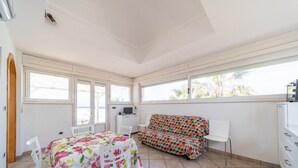A room with a dining table, a sofa, and a TV. - VILLA SUNSET - Villa facing the sea (Torre Suda)