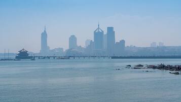 A city skyline with prominent buildings and a traditional pavilion by the waterfront.