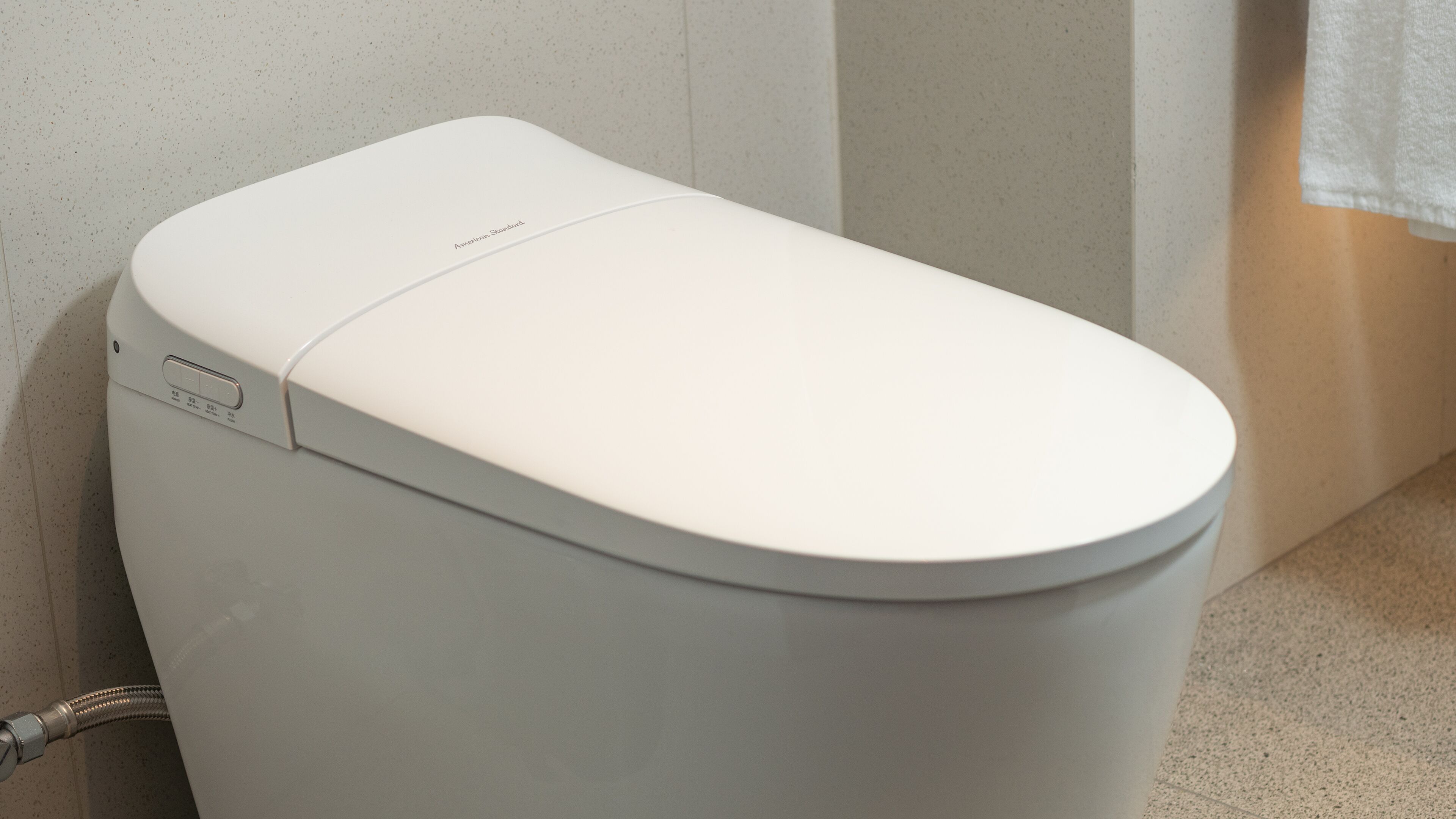 Eine weiße Toilette mit einer Bedienkonsole an der linken Seite.