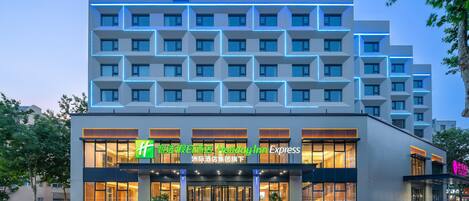 Welcome to Holiday Inn Express, featuring a modern facade with a grid-patterned design and a spacious entrance.