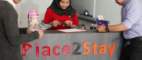A reception desk with a sign reading 'Place2Stay' and 'THE MINES'.