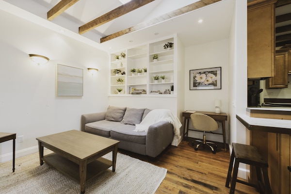 Living room features a sofa, desk, smart TV, and skylight.