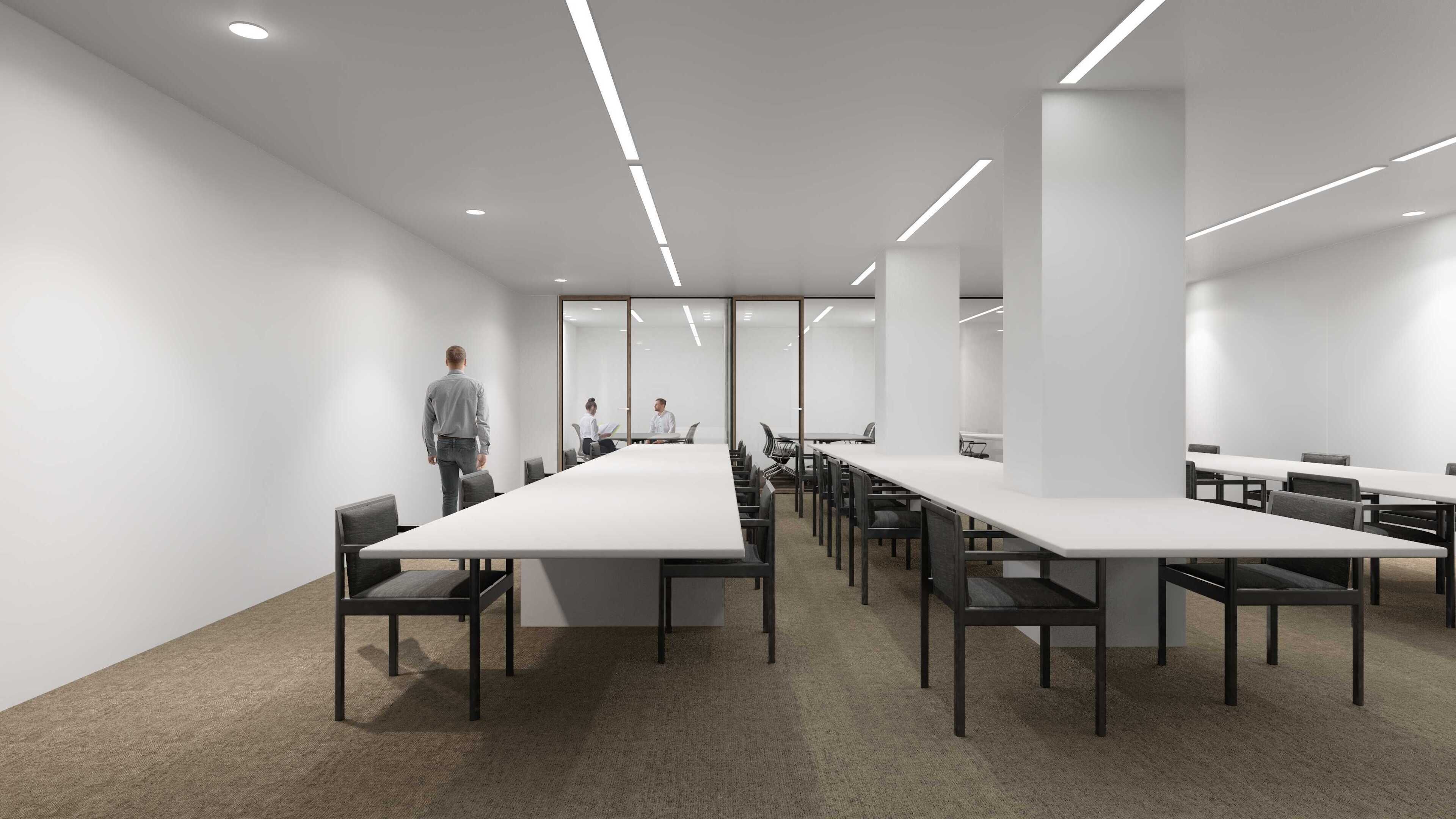 A modern conference room with long tables and chairs, white walls, and recessed lighting.