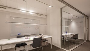 A conference room with a whiteboard, glass walls, and a long table with chairs. - Micampus Pamplona  (Pamplona)