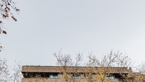 A multi-story building with a brick facade, large windows, and a central entrance with columns. - Micampus Pamplona  (Pamplona)