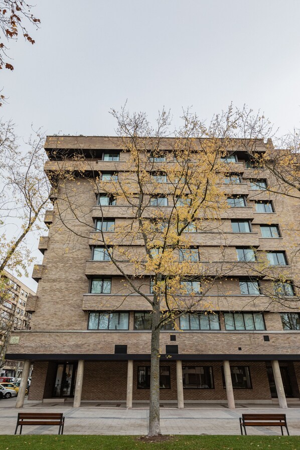 A multi-story building with a brick facade, large windows, and a central entrance with columns. - Micampus Pamplona  (Pamplona)
