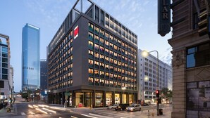 A modern hotel with a grid of windows, a prominent red logo, and a classic building facade. - citizenM Los Angeles Downtown (Los Angeles)