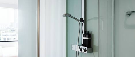 A modern shower with a handheld showerhead and a wall-mounted control panel.