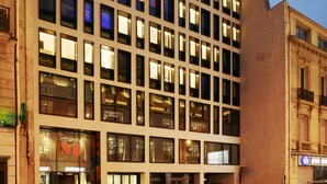 A multi-story hotel with a modern facade, large windows, and a prominent entrance with a glass door. - citizenM Paris Champs-Élysées (Paris)