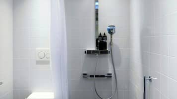 Un bagno moderno con doccia, toilette e una panca.