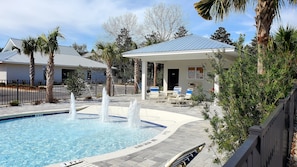Relax by the serene pool, surrounded by lush greenery and a shaded seating area.