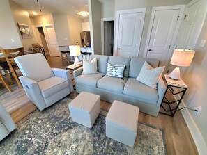 Relax in this stylish living room with a light grey sofa set and patterned rug.