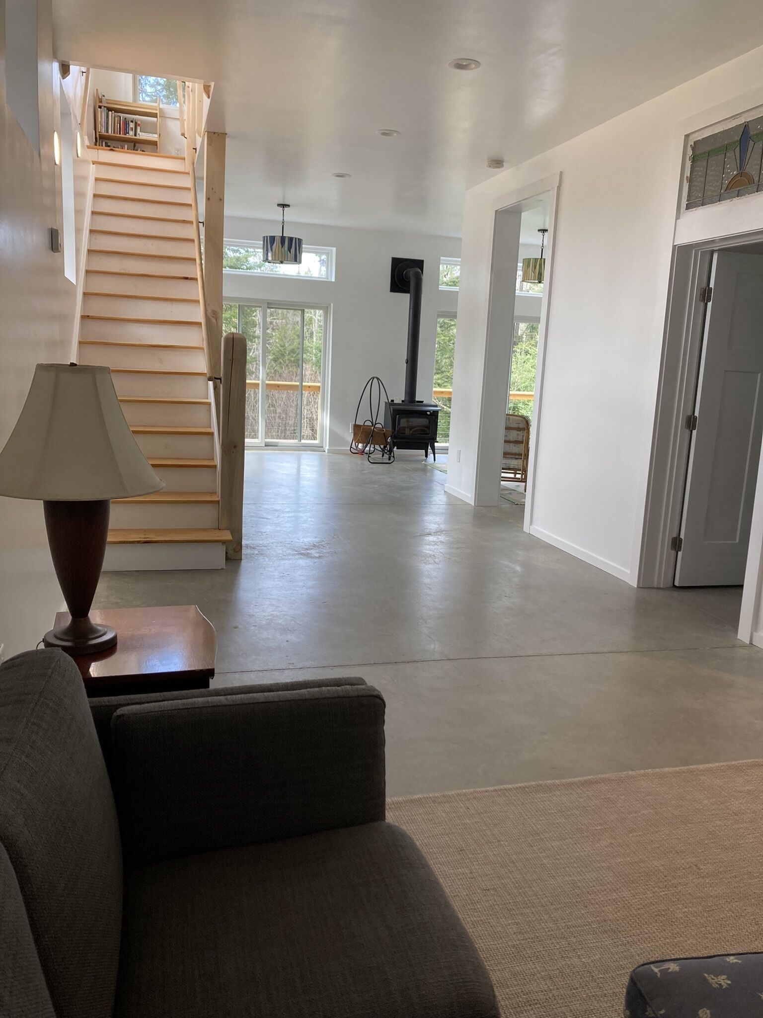 Uma sala de estar ampla com escada, lareira e vista para o exterior.