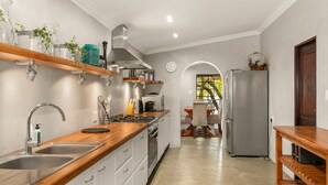 A modern kitchen with wooden countertops, stainless steel appliances, and a built-in oven. - Peaceful and Private - Luxury Self Catering Home in Lanseria (Lanseria)