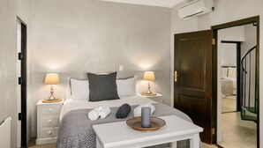 A bedroom with a bed, two bedside tables with lamps, a small table with a tray, a ceiling fan, and a door leading to another room. - Peaceful and Private - Luxury Self Catering Home in Lanseria (Lanseria)