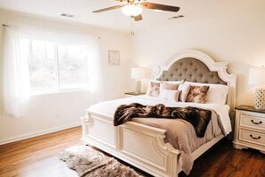 Classic bedroom with a large bed, bedside tables, and a plush throw.