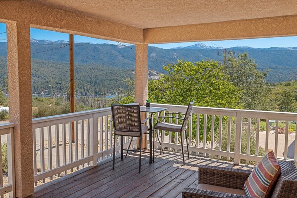 Enjoy dining or relaxing on the balcony with a view of the lush landscape and distant mountains.