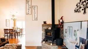 A cozy living room with a fireplace, wooden furniture, and decorative wall art. - Views of Bass Lake, whole house generator, BBQ, Outdoor dining, Mountain Views  (Madera County)