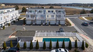 Un hotel de varios pisos con balcones, piscina y vistas a un río.