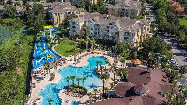 A resort with a large swimming pool, a water park, and multiple hotel buildings. - Luxury, Direct Entry Condo 2BR-2BA - Windsor Hills - Only 2 miles to Disney (Kissimmee)