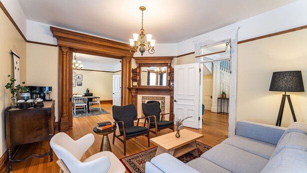 A spacious living room with a fireplace, a chandelier, and a modern sofa. - Heritage Location in Heart of Revelstoke (Revelstoke)