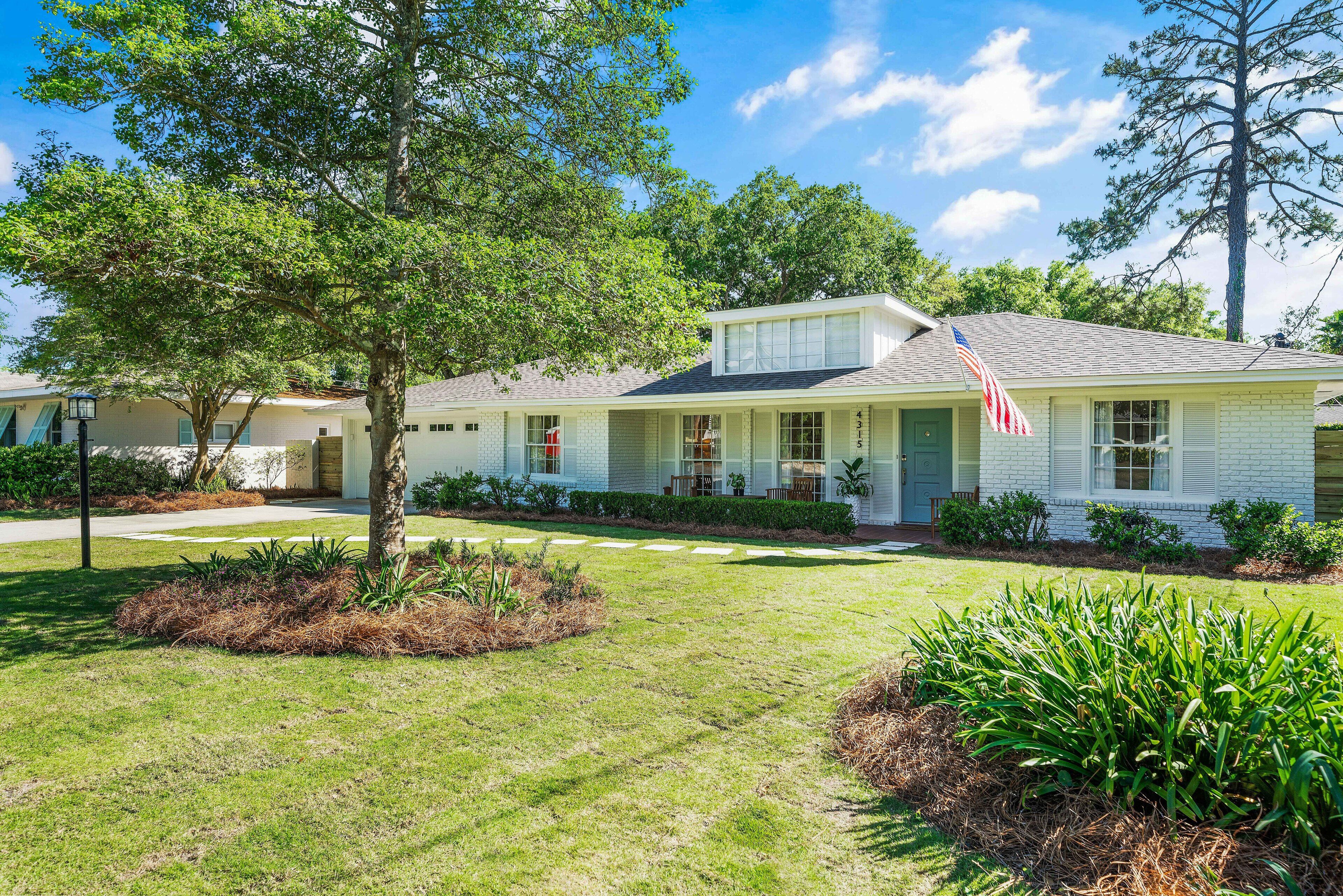 A single-story house with a front porch, a small attached garage, and a well-maintained lawn.