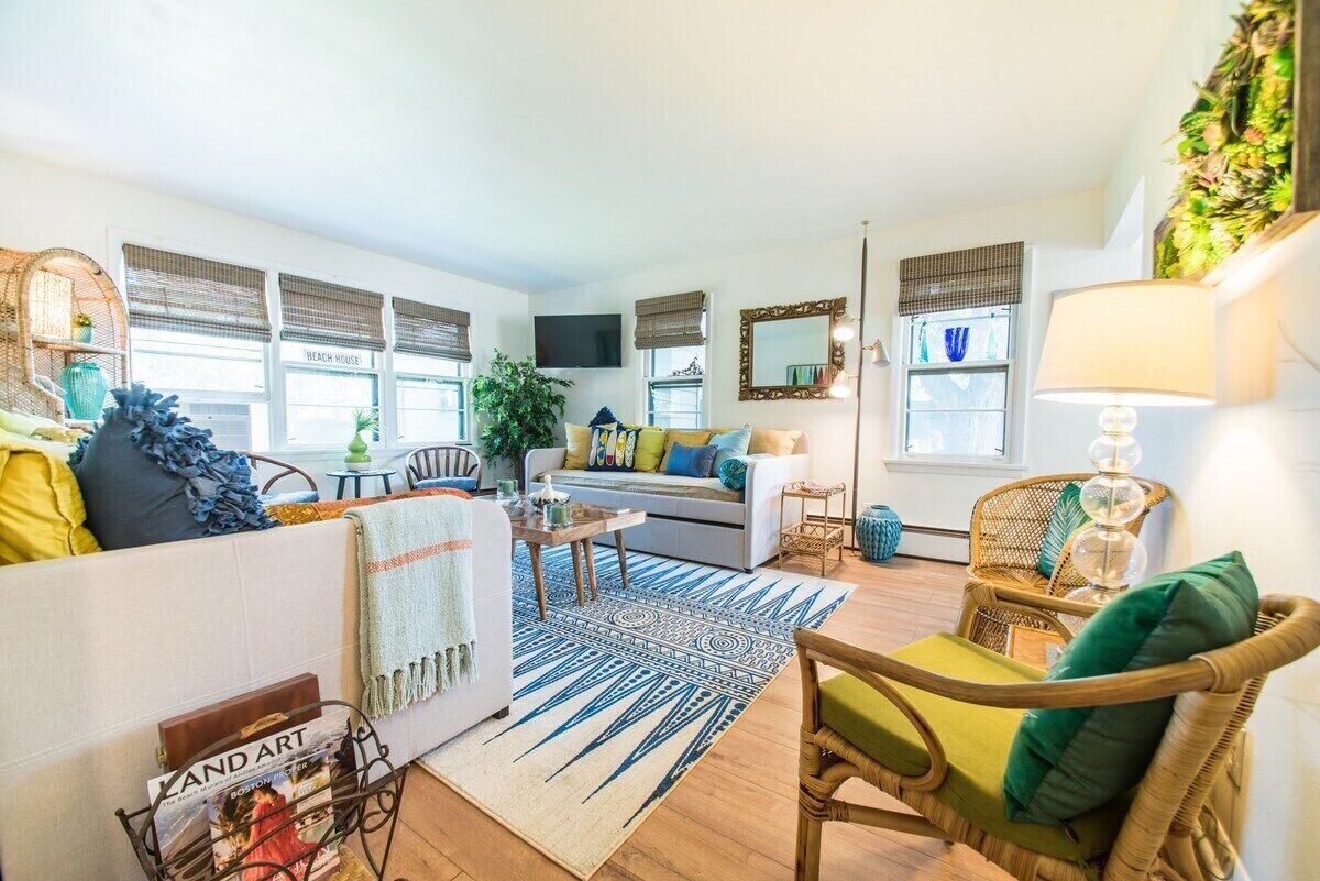 A living room with a sofa, chairs, a coffee table, and a TV.