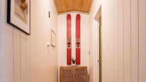 A hallway with white walls, a wooden ceiling, and a wooden cabinet with two red vertical elements. - Geneva Beach House Como Suite Walk to Lake Shore Path Near Downtown (Lake Geneva)