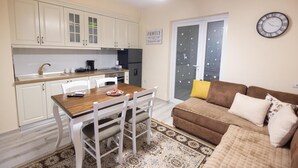 Un espacio habitable compacto con kitchenette, comedor y sofá.