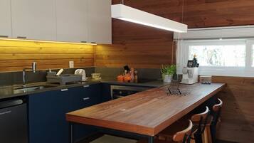 Una cocina moderna con una isla de madera, taburetes de bar y una ventana que proporciona luz natural.