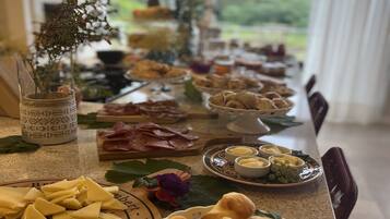 Una mesa de buffet con diversos alimentos, como queso, pan y salsas.