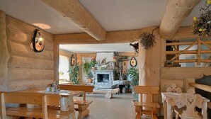 Un intérieur rustique en bois, avec des bancs et une cheminée.