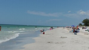 A beach with people swimming and sunbathing.