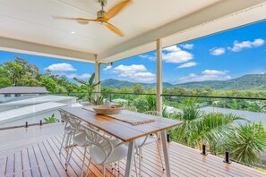 A wooden deck with a table and chairs, overlooking a mountainous landscape. - Airlie Abode (Jubilee Pocket)