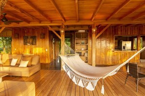 A wooden interior with a hammock, sofa, and dining area. - 3BR Ocean View Villa w/ Pool + Included Breakfast (Cobano)