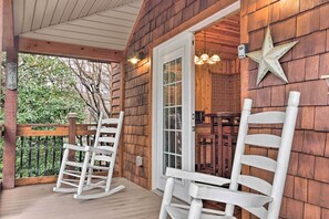 A wooden porch with rocking chairs, a star decoration, and a door leading to a room. - 'The Boat House' Creekside Escape in Hot Springs! (Hot Springs)